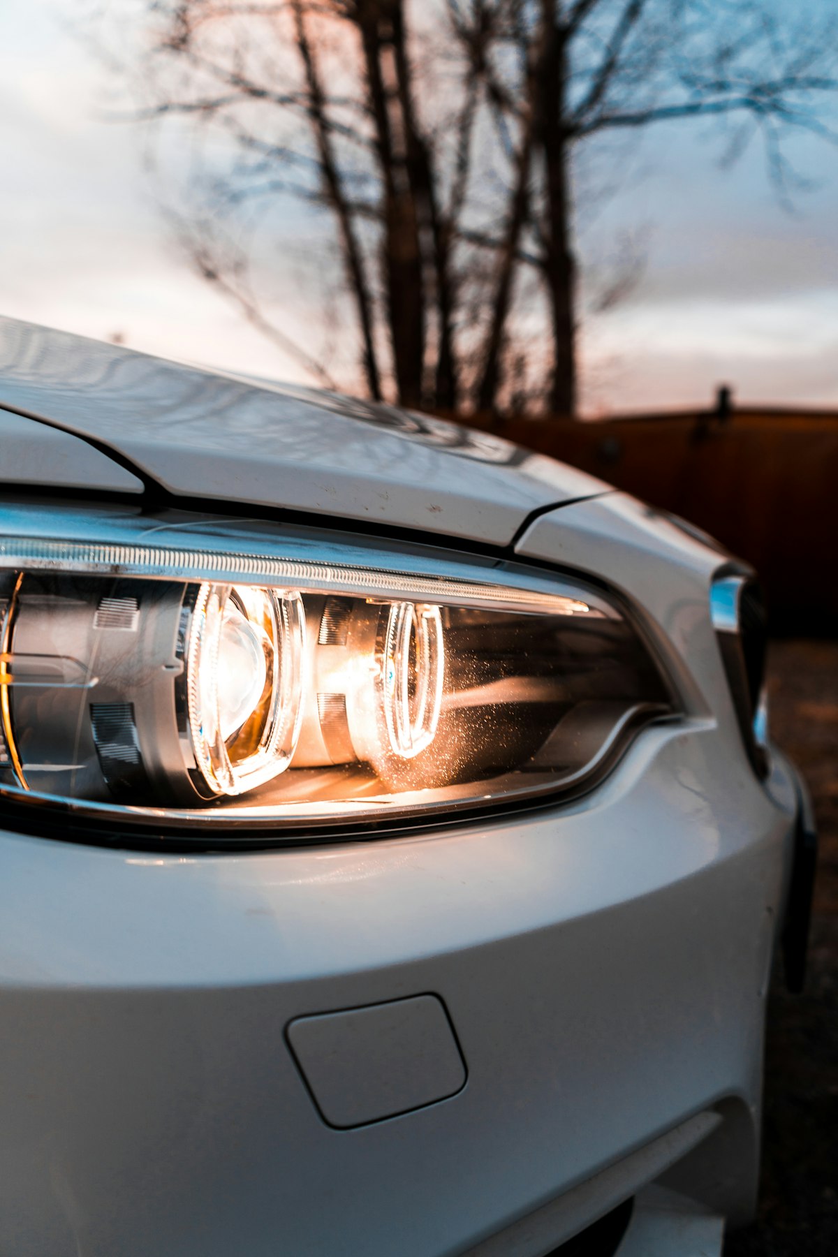 Close-up of a restored, clear car headlight at sunset